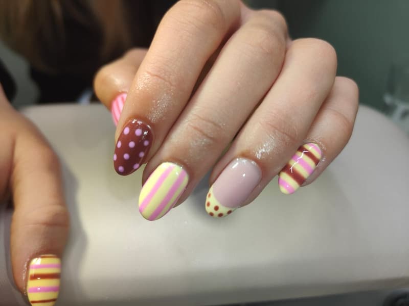 Nagels met stippen en strepen in lila, geel, bordeaux en roze